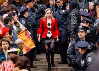 Arlequina de Lady Gaga beija uma mulher revoltada em cena de “Coringa 2”