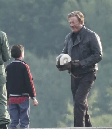 Brendan Fraser de jaqueta de couro e capacete na mao conversa com um garoto no set de A M&uacute;mia 4