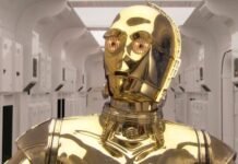 C-3PO caminha por um corredor de nave em Star Wars: Uma Nova Esperança