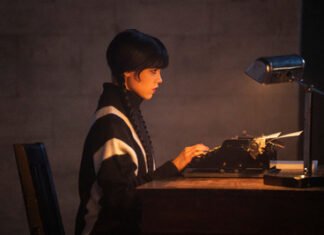 Jenna Ortega como Wandinha Addams sentada diante de uma máquina de escrever antiga